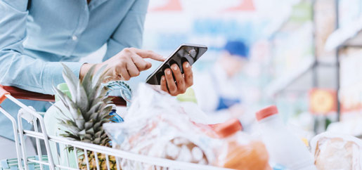 Donna che usa lo smartphone al supermercato